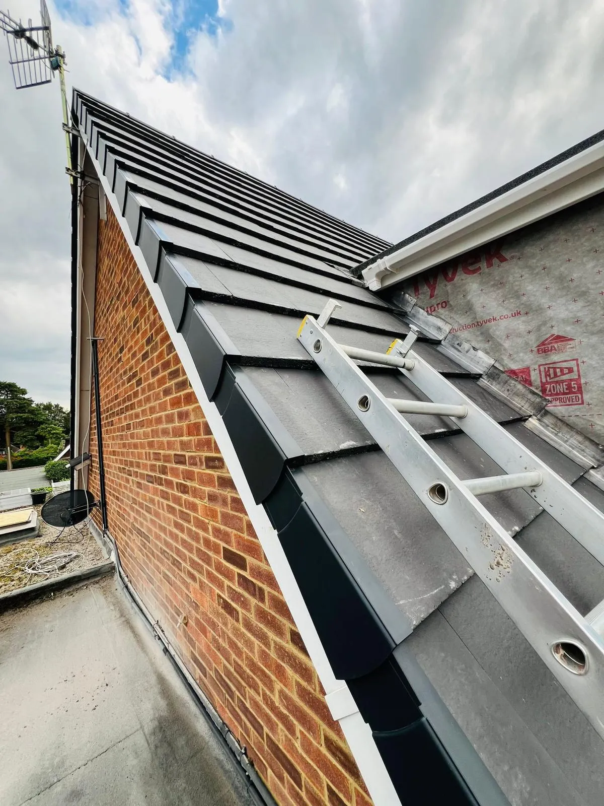 A brick building with a metal ladder attached to it.